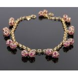 An 18ct gold bracelet, with ruby set ball shaped pendants, gross weight 7g.