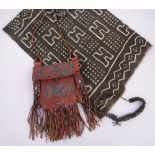 A group of Ethnic items, including a Tuareg bag, a handmade African cloth and a nut bead necklace,