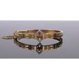 A Victorian 15ct gold ruby, pearl and diamond set hinged bangle, gross weight 10.5g.