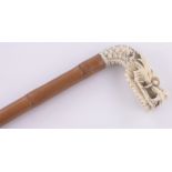 A Chinese ivory and bamboo cane circa 1900, with carved dragon's head finial, length 77cm.