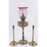A Juno brass oil lamp, with Cranberry frilled glass shade,