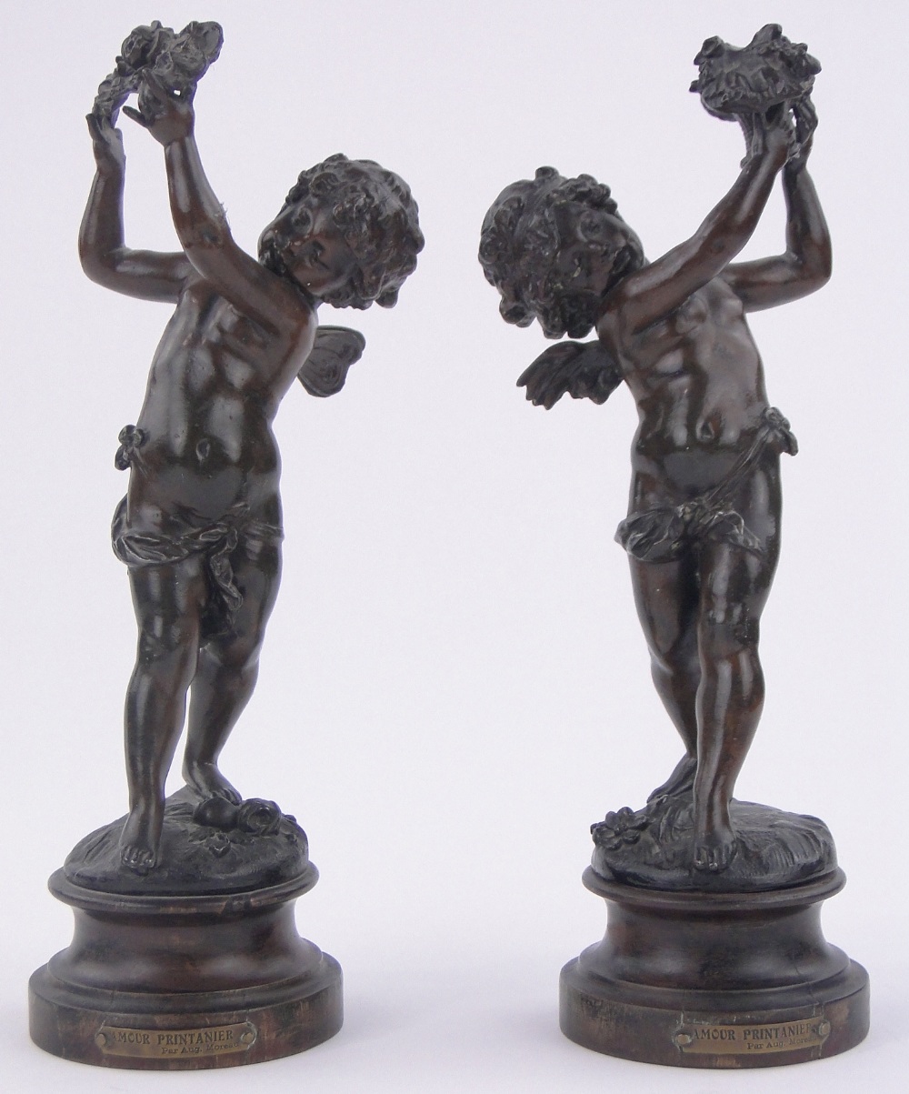 After Auguste Moreau- a pair of 19th century bronze-patinated spelter cherubs, turned wood plinths,