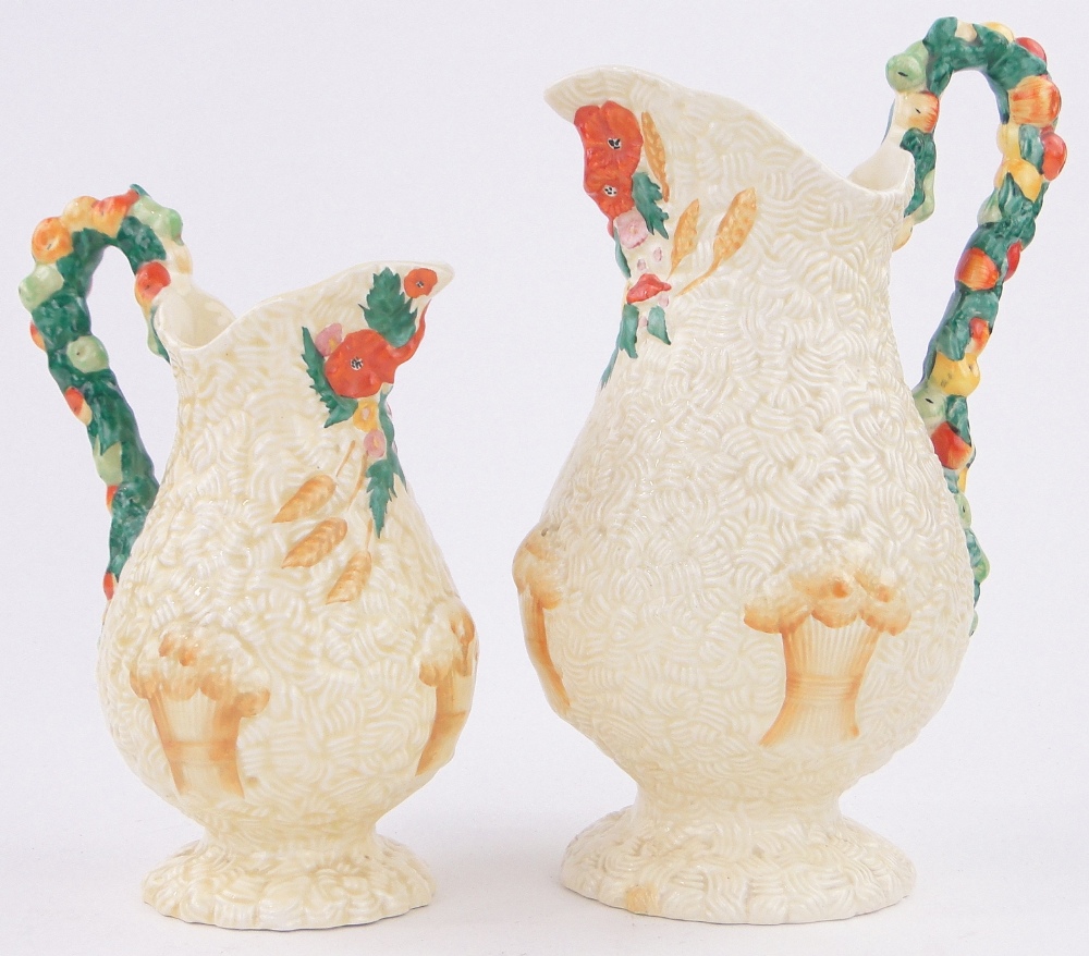A graduated pair of Clarice Cliff Barbola pattern jugs, with fruit embossed handles,