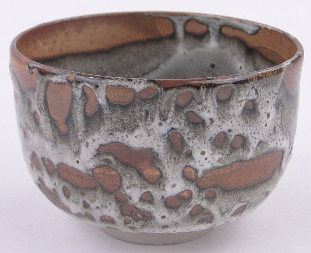 A Japanese treacle glazed ceramic Unomi bowl, impressed seal mark, diameter 11cm, height 7cm.