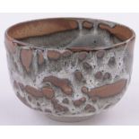 A Japanese treacle glazed ceramic Unomi bowl, impressed seal mark, diameter 11cm, height 7cm.