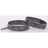 Pair of Chinese silver hinged bangles by Wang Hing, with raised Chinese character designs,