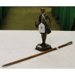 A swagger stick and a metal table lighter modelled as a Georgian gentleman.