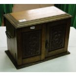 A carved oak smoker's cabinet with drawer fitted interior.