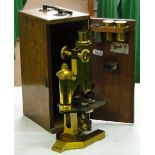 A brass student's microscope by R & J Beck of London, with accessories, in mahogany carrying case.