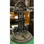 A cast-iron umbrella stand with original drip tray.