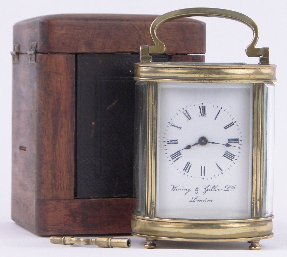 A French oval brass cased carriage clock, enamel dial, retailer Waring & Gillow, London, height