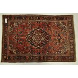 A red ground Persian rug, medallion Mohtasham design, with symmetrical border,