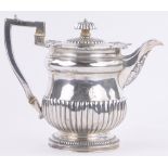 A George III silver teapot, of half fluted form, with engraved armorial crest, maker William Eaton,