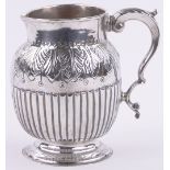 A George III silver jug, with leaf embossed shoulders and half fluted body,