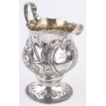 A George III silver cream jug, chased and embossed floral bands by William Kinman, London 1764,