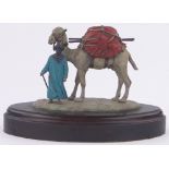 An Austrian cold painted bronze Bedouin tribesman and camel, unmarked, wooden plinth,