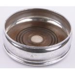 A modern circular silver wine coaster, with turned wood base, by MC Hersey, London 1991,