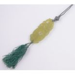 A Chinese relief carved and pierced jade pendant on silk cord, pendant length 70mm.