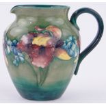 A Moorcroft pottery Iris pattern jug, painted signature, height 16cm.