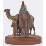 An Austrian painted spelter table lighter in the form of Arab carpet sellers and camel,