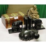 A soapstone hippo, ebony elephant bookends, brass mother and child, and a brass bound box.