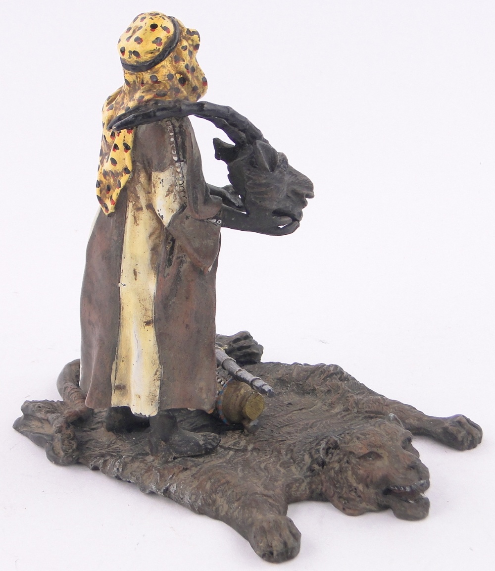 A cold painted bronze Arab huntsman standing on a tiger's skin rug, length 16cm, height 15cm. - Image 2 of 3