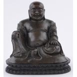 A Chinese patinated bronze seated Buddha, on lotus leaf decorated carved wood base,