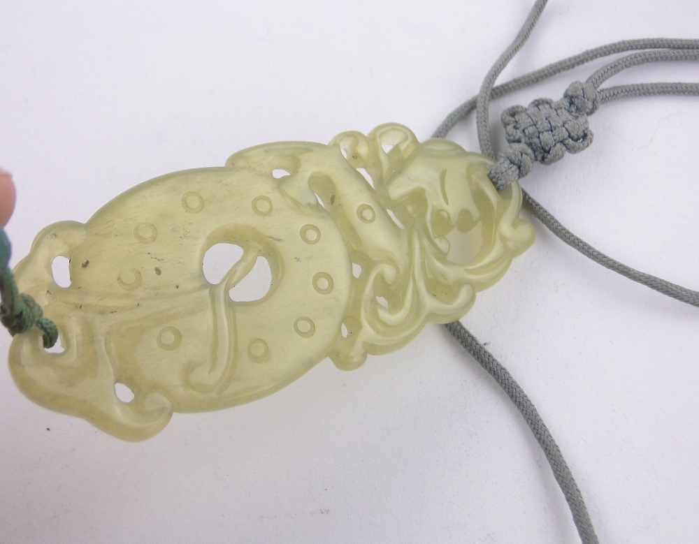 A Chinese relief carved and pierced jade pendant on silk cord, pendant length 70mm. - Image 3 of 3
