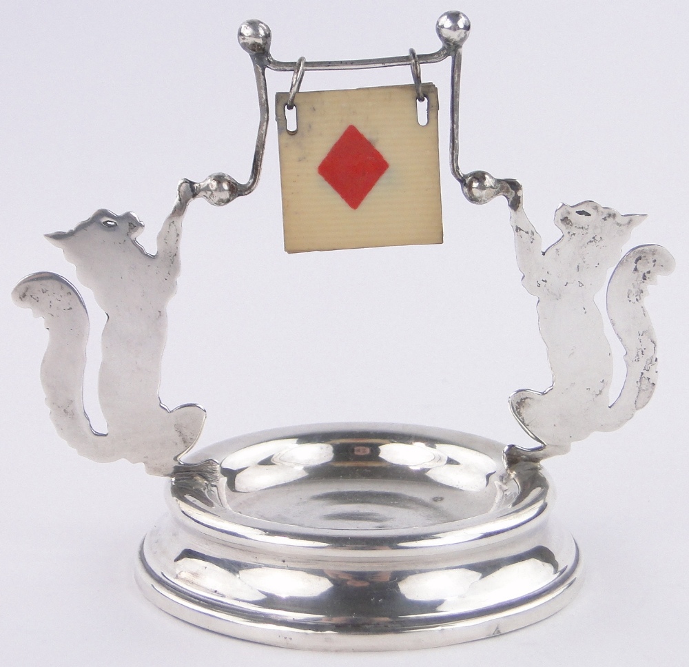 A silver bridge marker, with cat silhouette supports, London 1921, base diameter 8.5cm.