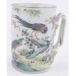 A Chinese porcelain mug, with painted enamel exotic birds and flowers, crossover handle,