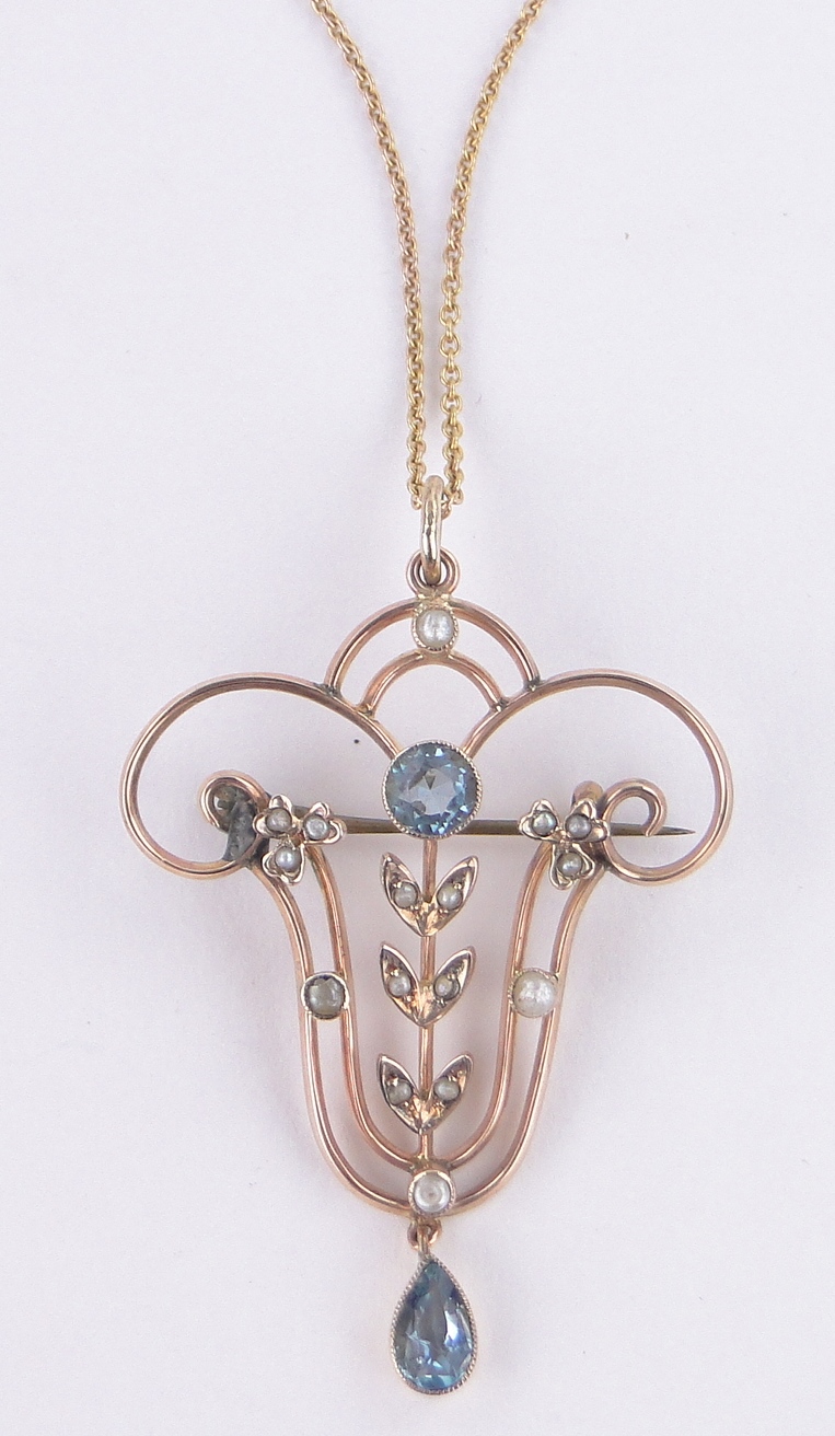An Edwardian aquamarine and pearl set openwork pendant/brooch, unmarked gold settings,