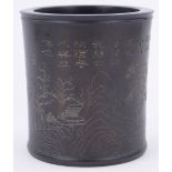 A Chinese cylindrical hardwood brush pot, with engraved mountain landscape and lines of text,