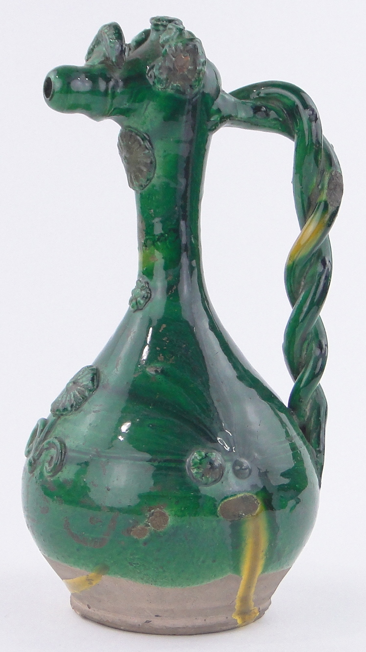 A large European green glazed pottery jug, with applied floral designs and twist handle,