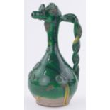 A large European green glazed pottery jug, with applied floral designs and twist handle,