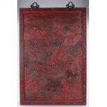 A large Chinese relief carved red lacquer wall panel,