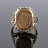 A 9ct gold signet ring set with a Cameo carved tigers eye panel, setting height 18mm, size R.