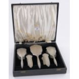 A 5-piece engraved silver backed brush and mirror set, Birmingham 1957, original case.