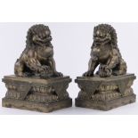 A pair of large Chinese bronze ceremonial lions, on ornate lotus leaf plinth bases, height 45cm,