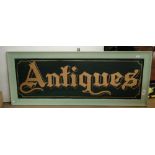 A framed painted card Antiques sign.