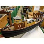 A scratch-built painted wood tug boat.