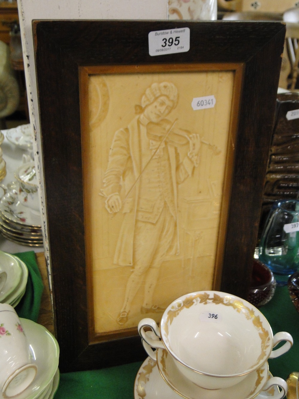 Antique framed tile depicting a musician.