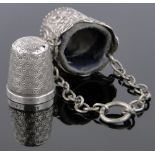 An ornate continental silver thimble case and thimble.