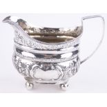 A George III silver cream jug, with chased floral designs, indistinct makers marks, London 1805, 3.