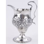 A George III silver helmet shaped cream jug, relief decorated floral body, by Samuel Meriton,