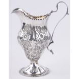 An Antique relief embossed silver helmet shaped cream jug, indistinct marks, 2.9 oz.