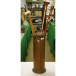 Various walking sticks, etc., in a copper stick stand.