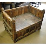 An Eastern hardwood hall bench with rising lid, iron strapwork decoration.