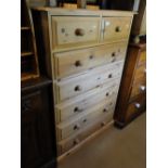 A modern pine chest of 7 drawers.