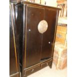 A Oriental black lacquered 2-door cupboard with drawers under.