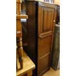 An oak canted corner hall cupboard with linen fold panelled door,